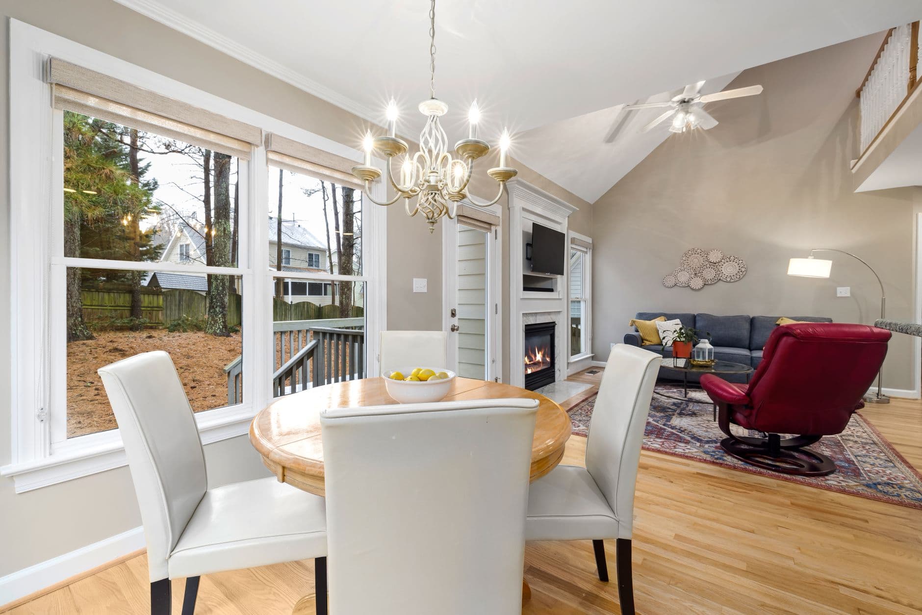Bright open plan living area featuring a cozy fireplace and dining set.
