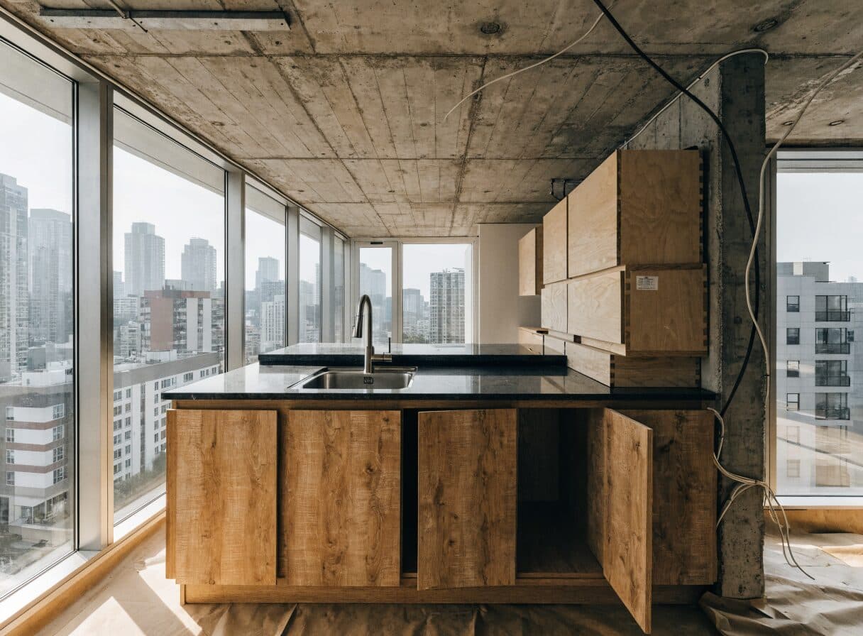 Vancouver high-rise condo kitchen renovation in progress with city views through floor-to-ceiling windows