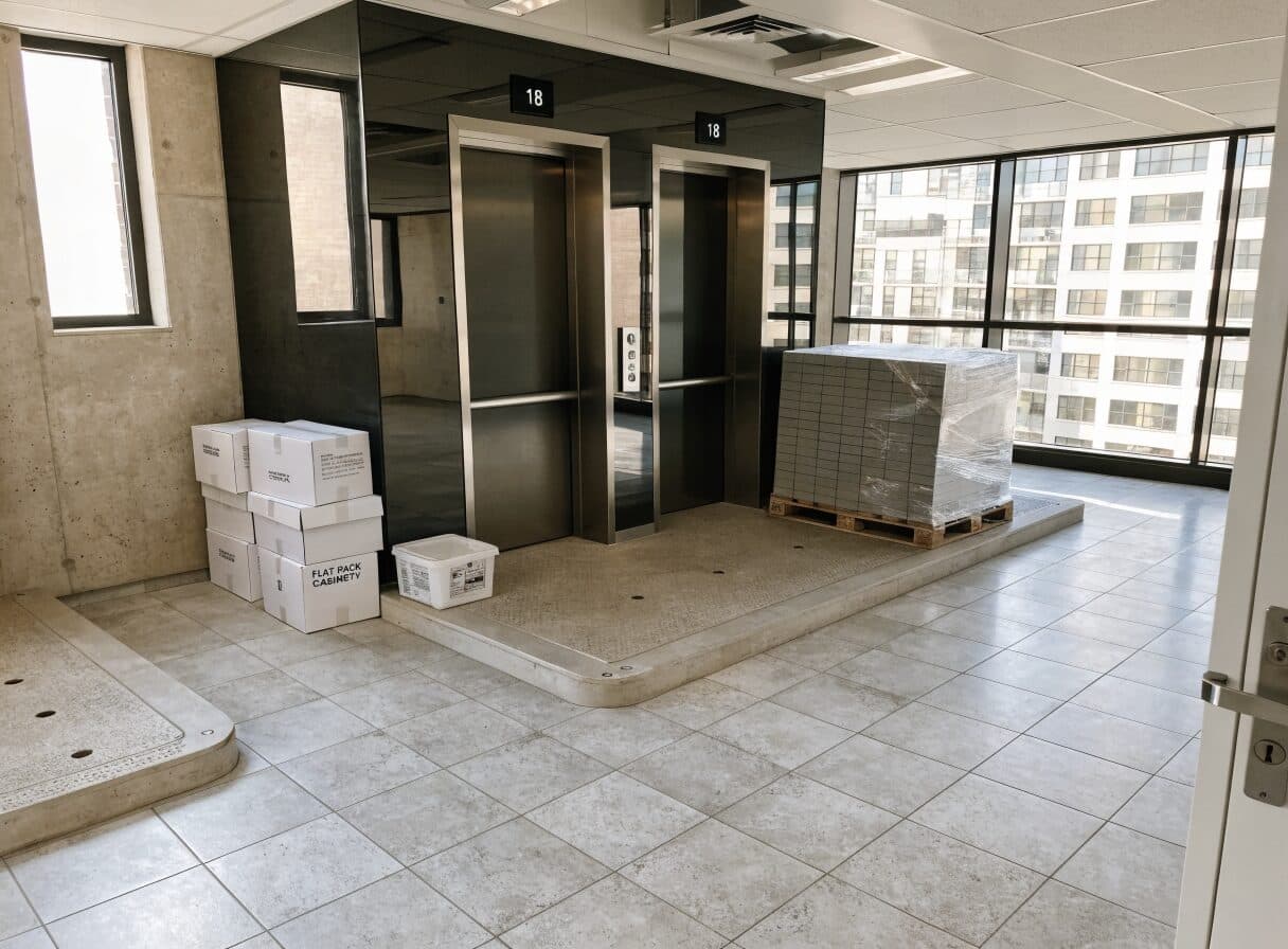 Elevator foyer with protective pads and renovation materials staged in a Vancouver residential high-rise lobby