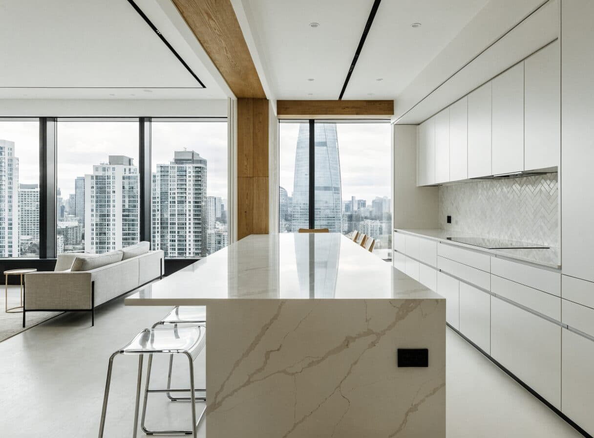 Completed modern Vancouver condo renovation with white handle-free cabinetry and city skyline views