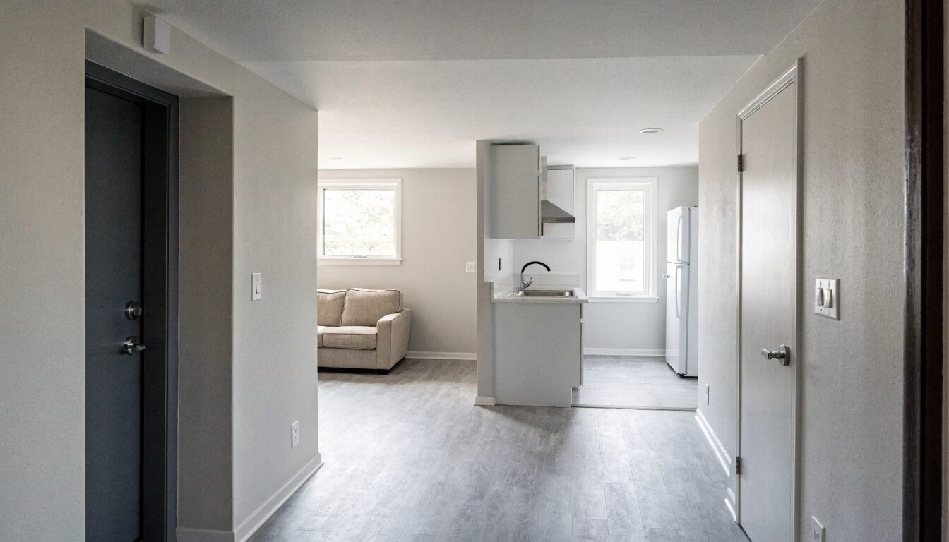 Legal basement suite in a Surrey home: open-plan living area with modern kitchen, separate entry, and egress windows.