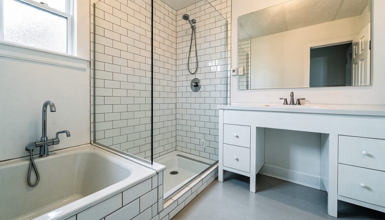 Primary suite bathroom renovation in a Surrey home: freestanding tub, large-format tile, and frameless glass shower.