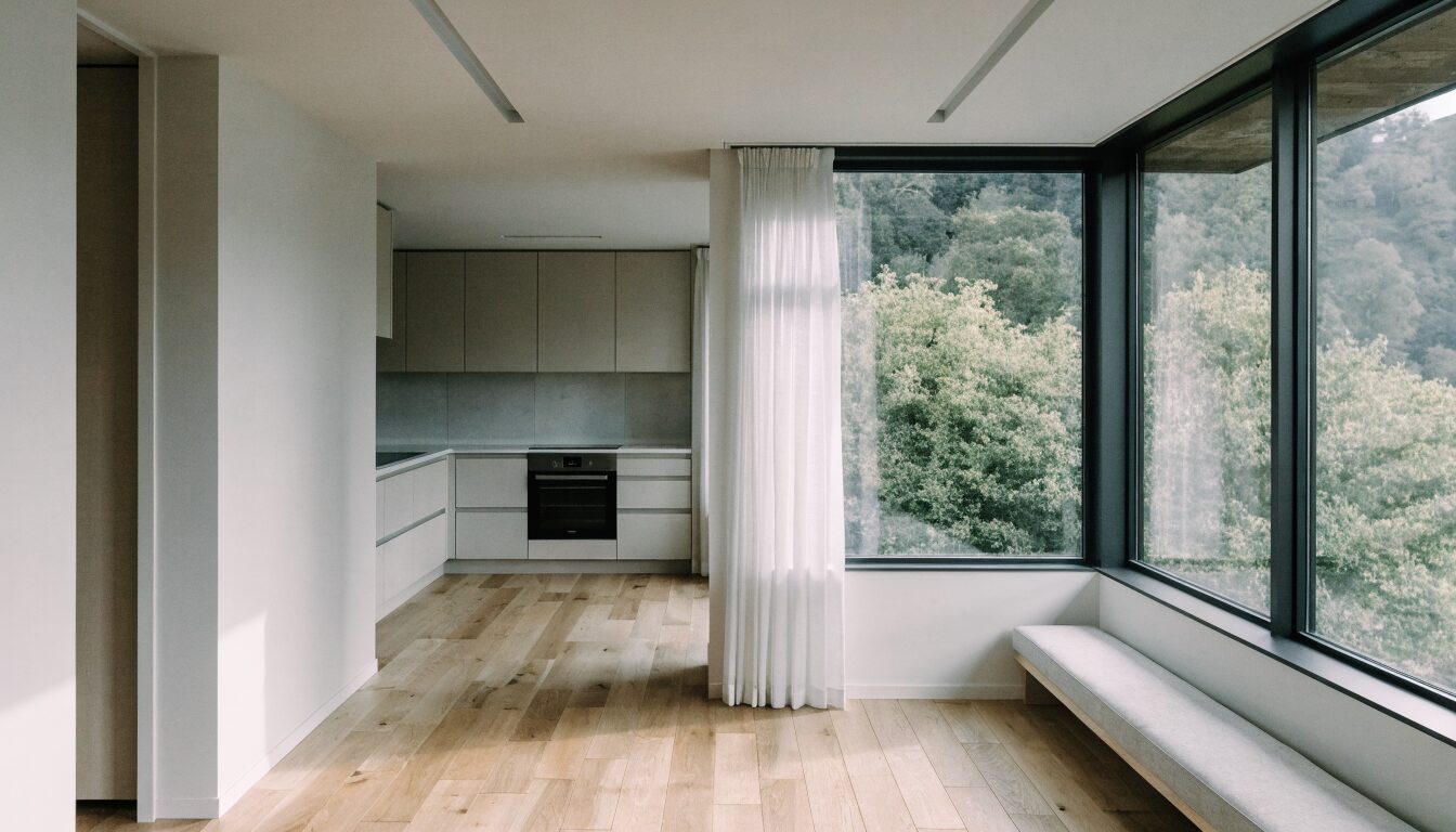 Renovated open-plan interior in a Richmond BC home featuring modern kitchen and dining area with large windows.