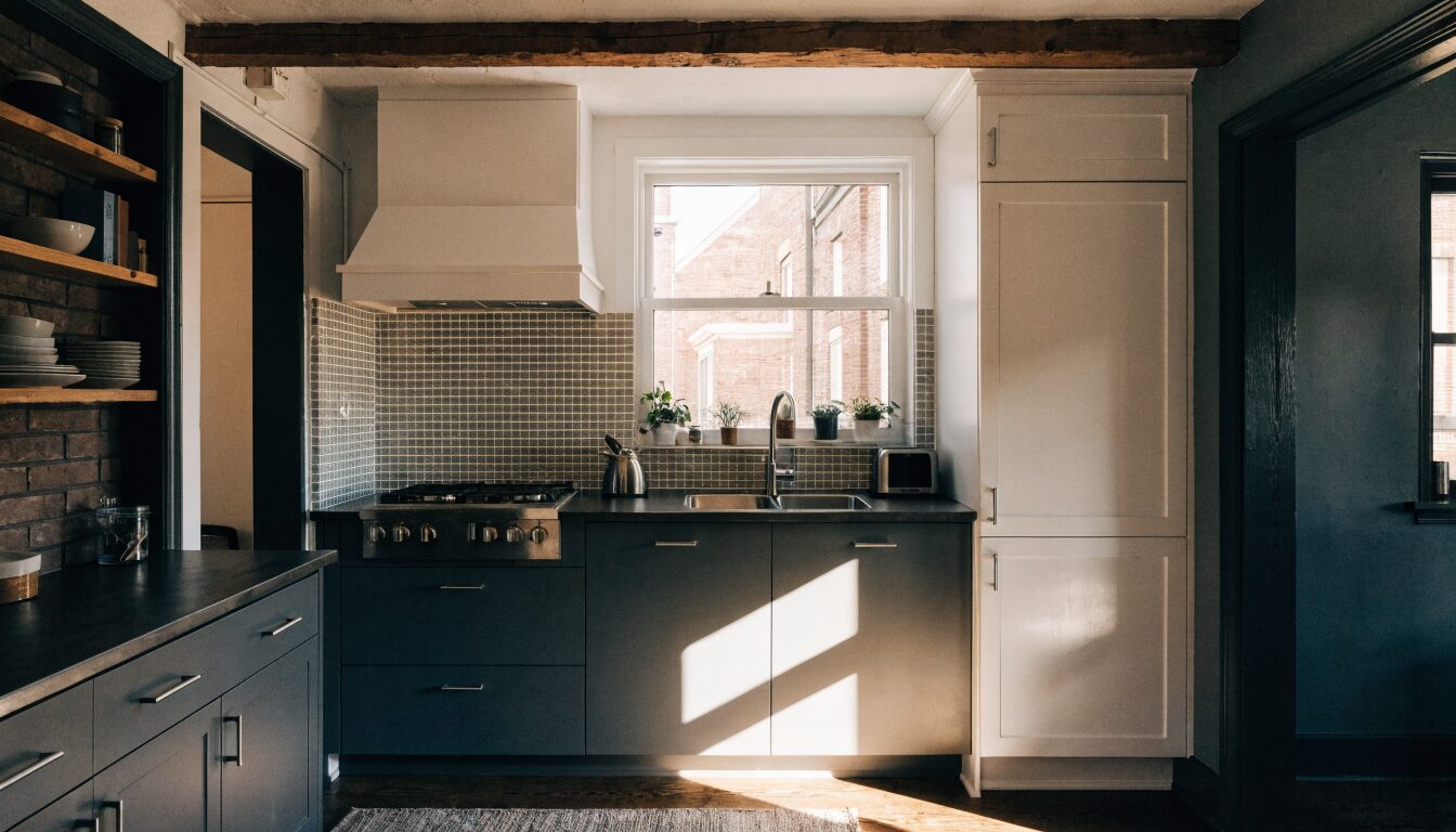 Modern kitchen renovation in a Vancouver home: white cabinetry, stone countertops, and warm hardwood floors.