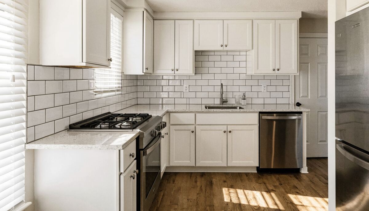 Completed entry-level Vancouver kitchen with white Shaker cabinetry, subway tile backsplash, and quartz countertop