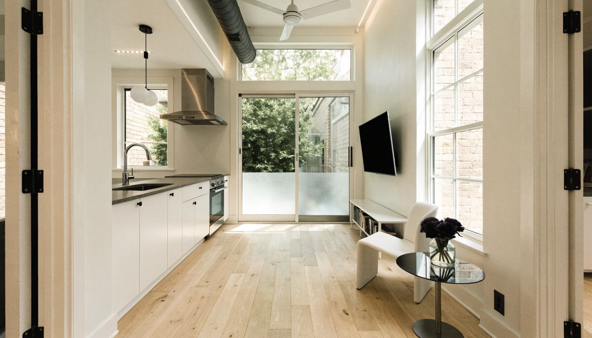 Bright modern laneway house interior with open-plan kitchen and living area, white oak floors and large windows