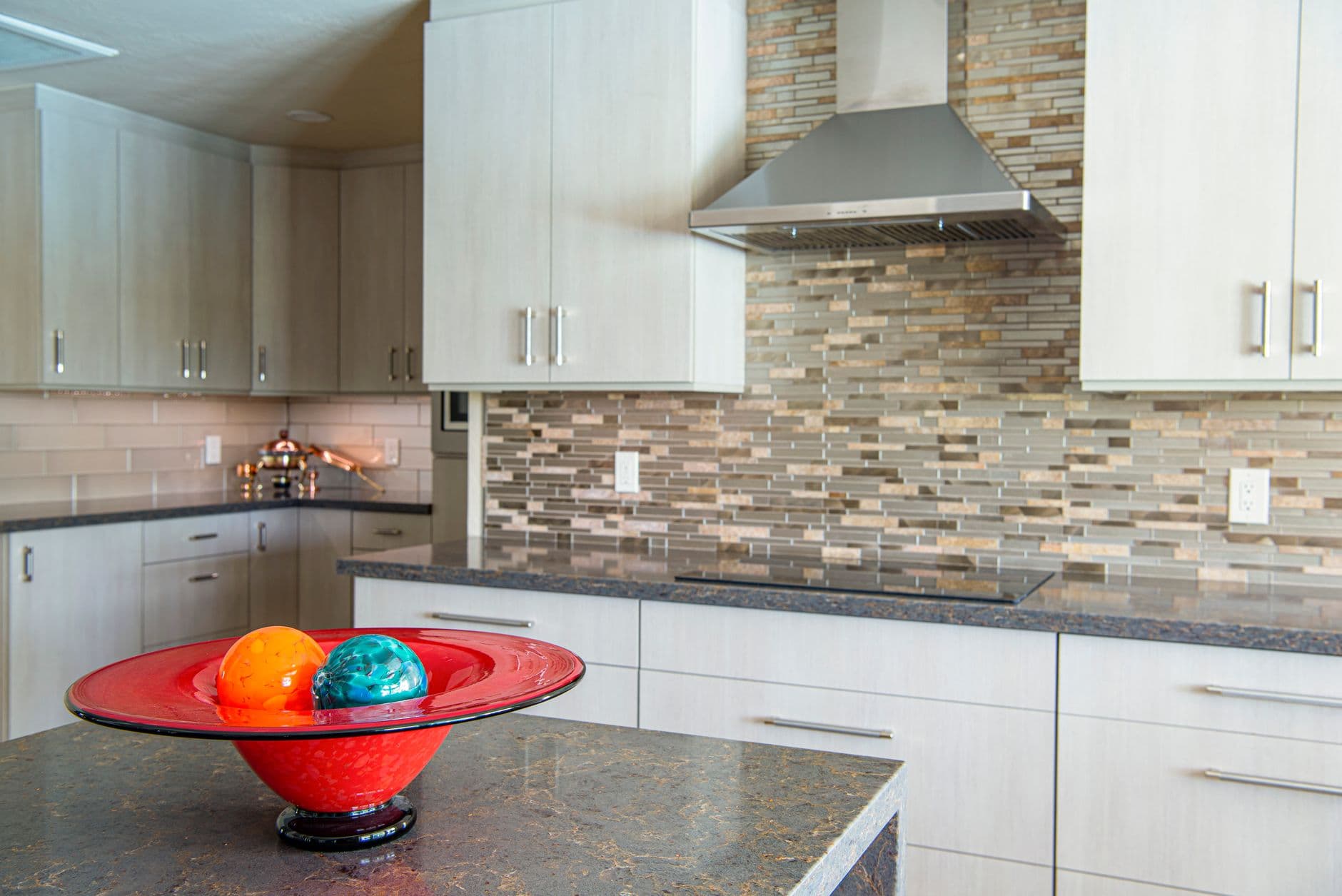Sleek kitchen design featuring a red bowl with decorative accents.